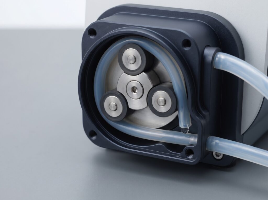 close-up of peristaltic pump rollers compressing silicone tubing inside a dosing pump head
